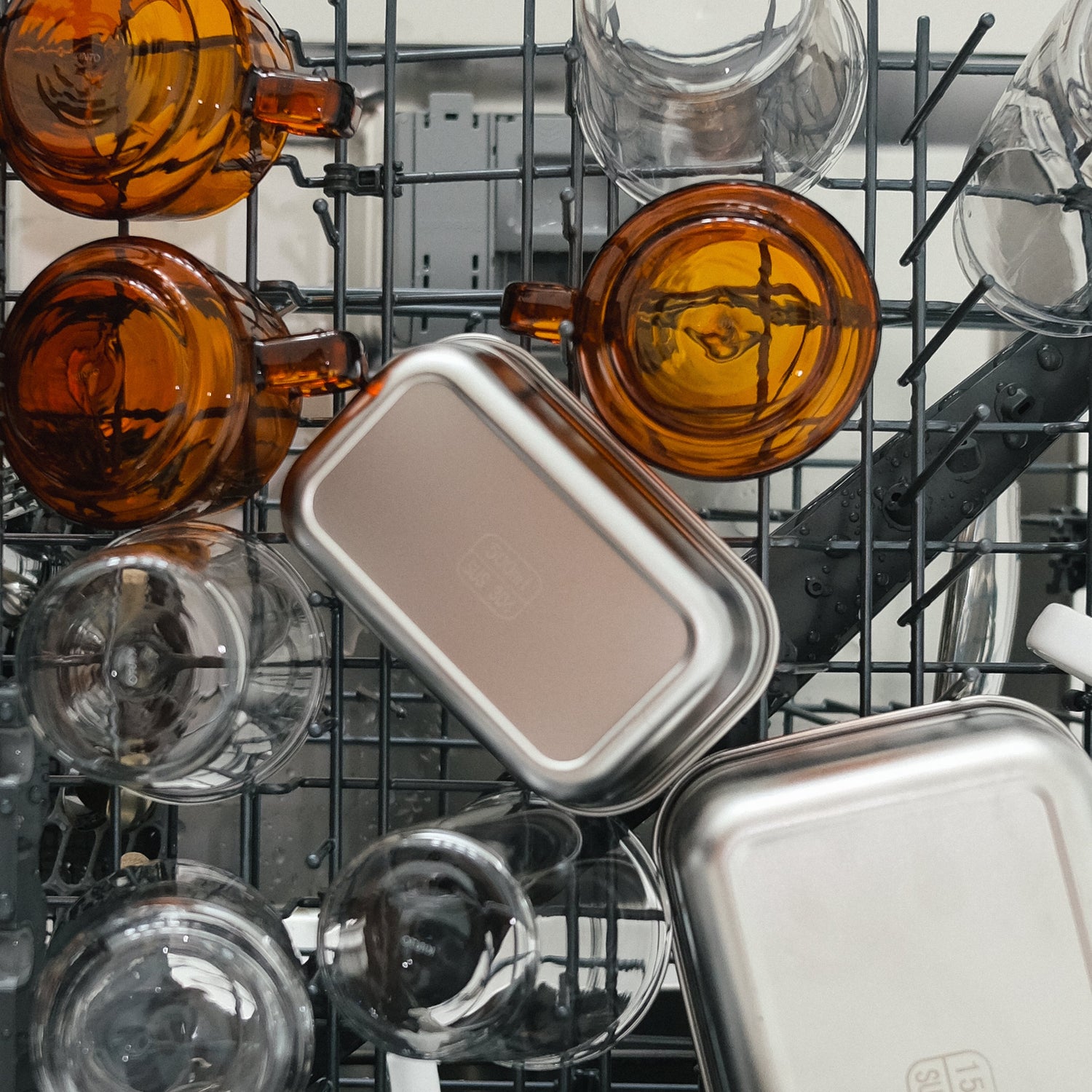 Dishwasher interior with glassware and metal containers